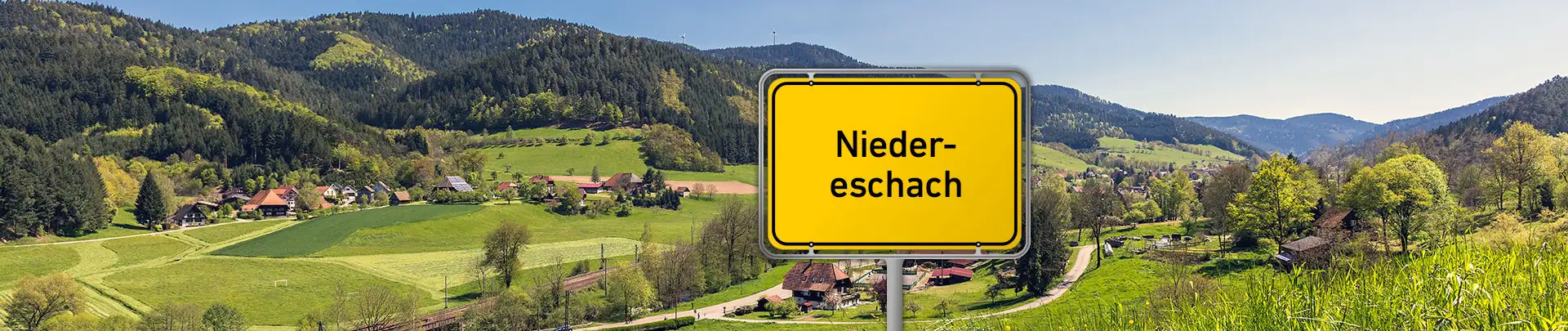 Ortsschild von Niedereschach vor Schwarzwaldlandschaft