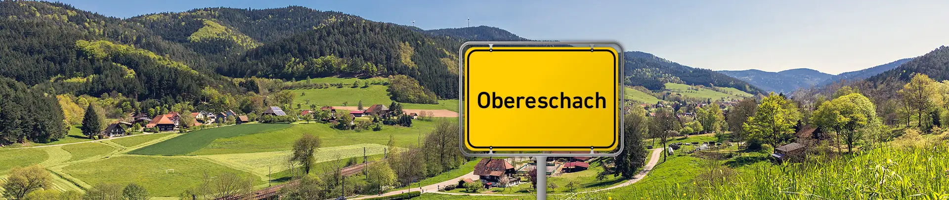 Ortsschild Obereschach vor Schwarzwaldlandschaft