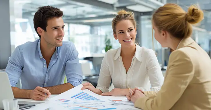 Drei Personen im Gespräch über Immobilienverkauf