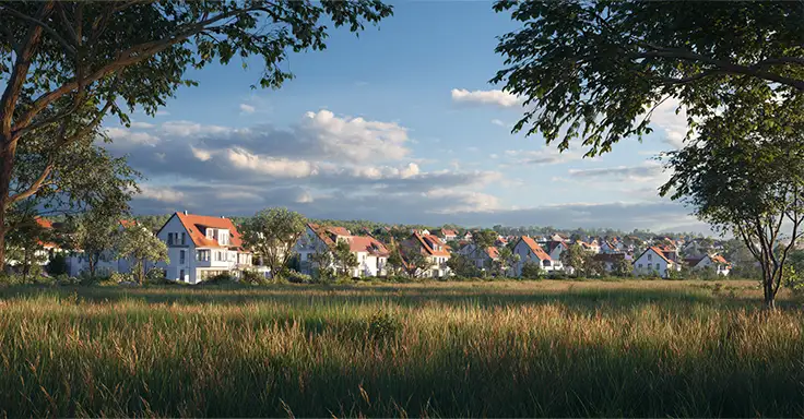 Weite Wiese mit Häuserreihe im Hintergrund